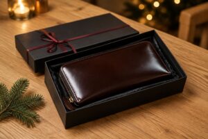 赤いリボンの黒いギフト箱に入った濃い茶色のコードバン長財布